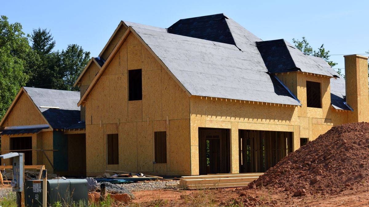 A new house under construction with exposed wood framing and roof sheathing