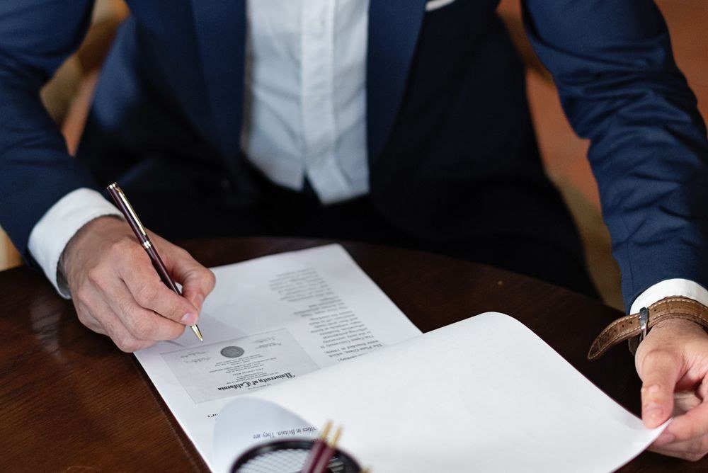 An investor signing loan documents at a desk, standing in for the personal guarantee that sits behind an LLC-vested DSCR loan